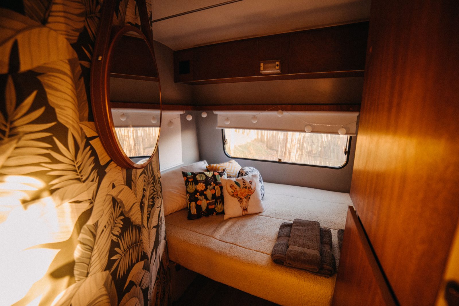 Cozy camper interior with throw pillows and warm light coming through the window