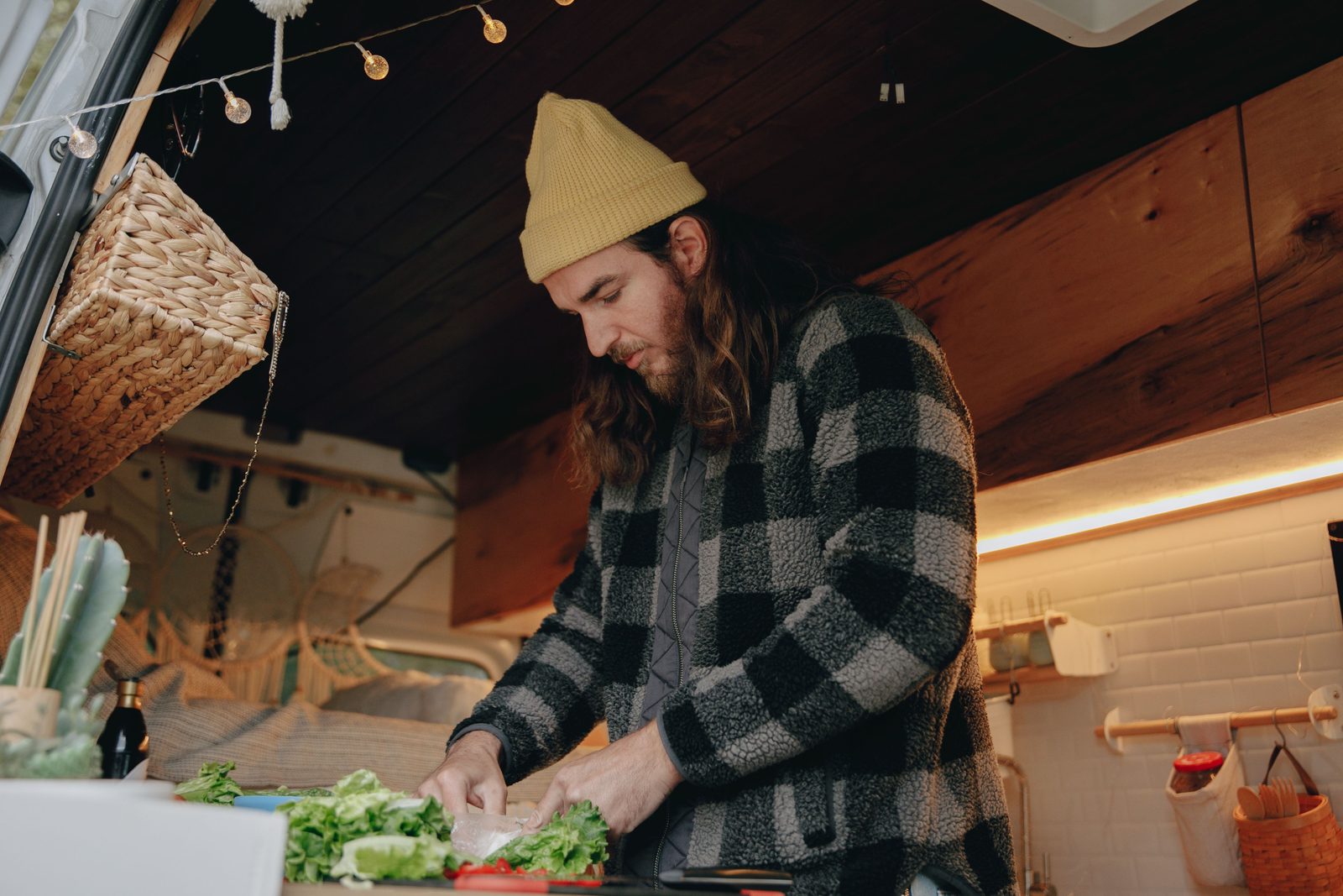 Camper galley with fresh vegetables being chopped on the counter
